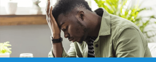 A man holding his head in pain from a migraine attack